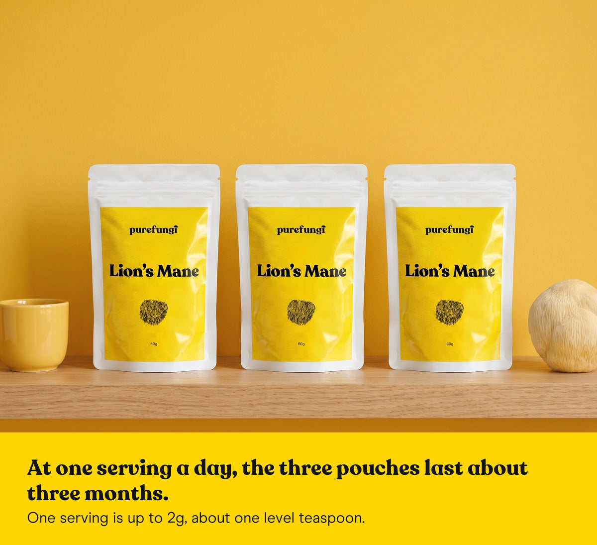 Three Lion's Mane powder pouches on a wooden shelf with a Lion's Mane mushroom and a yellow cup