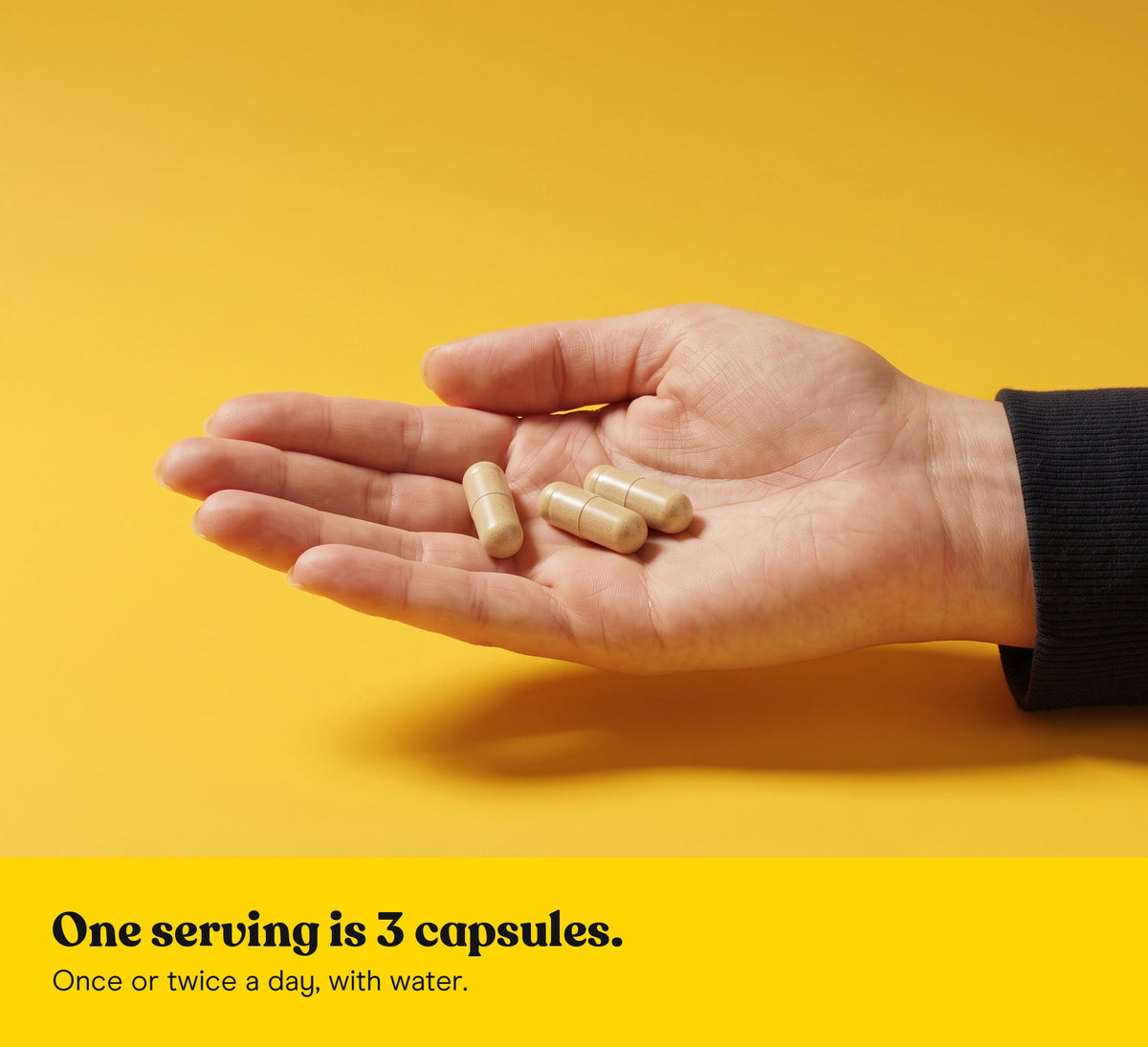 Three Lion's Mane extract capsules in an open hand on a yellow backdrop: one serving is 3 capsules, once or twice a day, with water