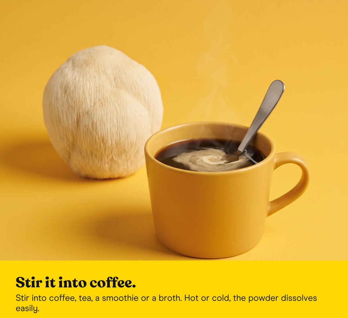 Lion's Mane extract powder stirred into a yellow cup of coffee, a Lion's Mane mushroom behind