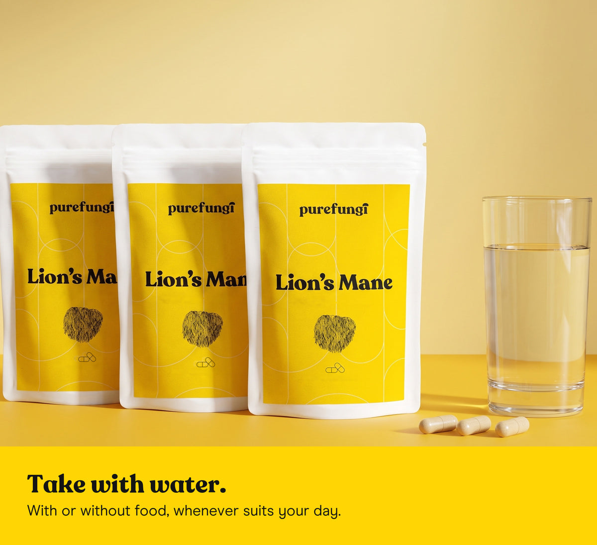 Three Lion's Mane capsules pouches with a glass of water and three capsules